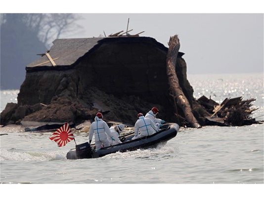 Японски военни, облечени в защитни костюми, търсят тела в морето.
СНИМКИ: РОЙТЕРС