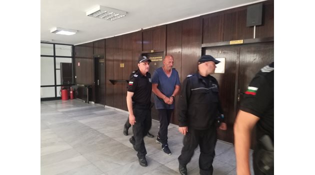 Полицаи водят Петричкия Ескобар към съдебната зала.
