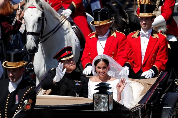 Британският принц Хари и съпругата му Меган Маркъл махат на тълпата, докато обикалят Уиндзор в открита каляска “Аскот” след сватбената церемония.