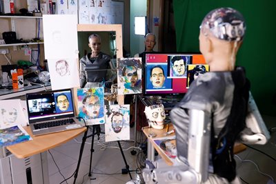 Хуманоидният робот София рисува на лист хартия, преди да продаде собствените си произведения на изкуството на търг в Хонконг. СНИМКА: РОЙТЕРС