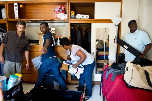 Родители помагат на сина си да подреди багажа си в стая на общежитието на университета