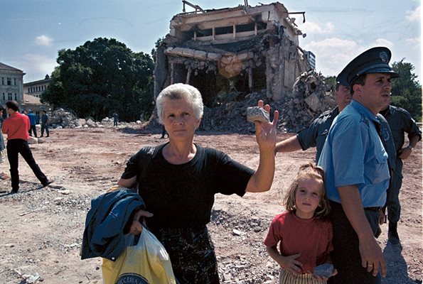Жена показва парче от разрушения мавзолей, което си е взела за спомен.
