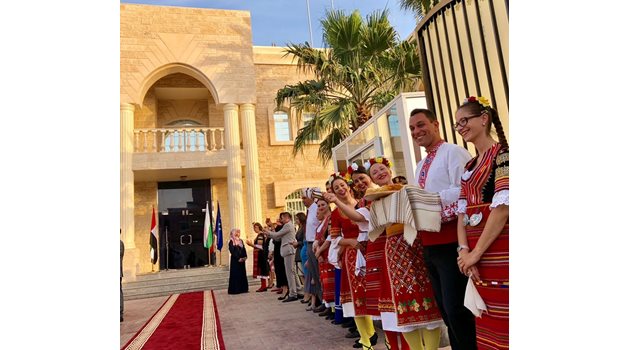 Българи, живещи в ОАЕ облечени в национални носии очакват с хляб и сол българския външен министър пред сградата на новото посолство.