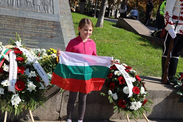 A child proudly poses with a tricolor after presenting a flower to the Independence Monument in Sofia.