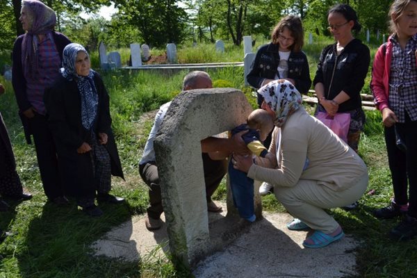 Хора се провират за здраве през отвор, изсечен в камък.