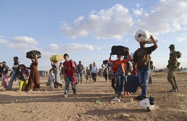 Сирийски кюрди, носещи вещите си, преминават границата от Сирия в Турция, бягайки от настъпващите джихадисти.
архив