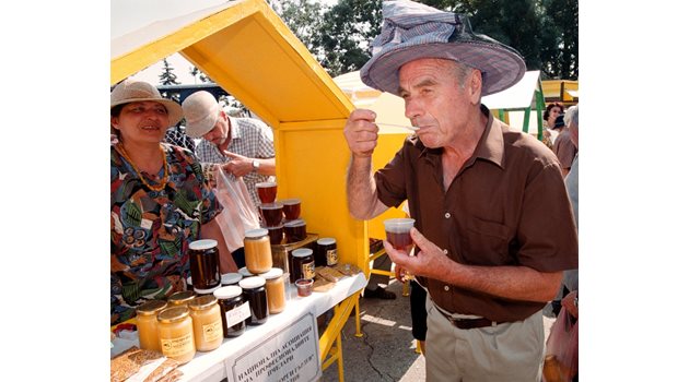 Възрастен мъж опитва мед на фермерски пазар. Плановете на държавата са да направи специални пазари, на които стари хора ще продават собствена продукция.