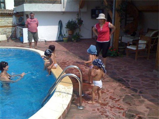 Децата си играят в басейна на Марияна Костадинова в двора на къщата й в търновското село Миндя.
