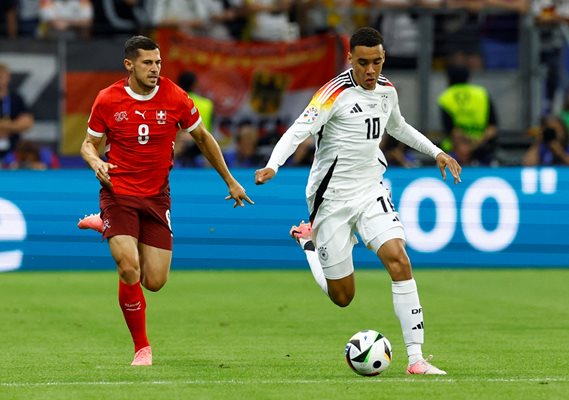 Germany's Jamal Musiala takes possession in front of Switzerland's Remo Frouehler during the Euro 2024 Group A match in Frankfurt.  PHOTOS: Reuters