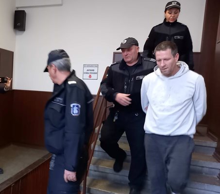 Охраната води Ангел Захариев към съдебната зала.