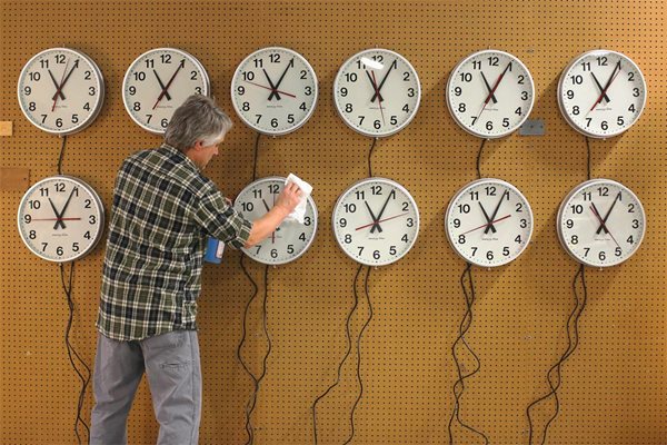 Американец почиства часовници преди преминаване към лятното часово време.