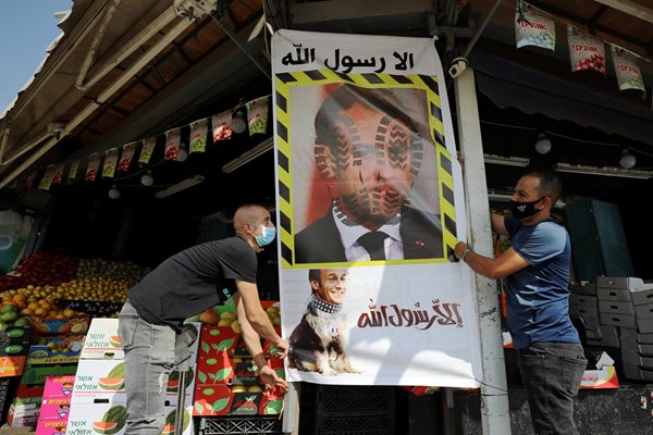Продавачи в арабския квартал на Йерусалим поставят плакат срещу Макрон.

