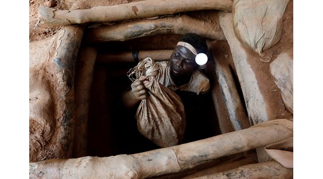 Миньор излиза от златна мина с торба камъни, които е изкъртил под земята в нелицензиран рудник в Нсуаем Топ в Гана.  СНИМКА: РОЙТЕРС