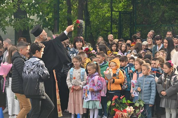 Отец Божидар, който отслужи водосвет в 122-о училище, благославя децата.