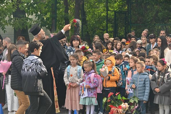 Отец Божидар, който отслужи водосвет в 122-о училище, благославя децата.