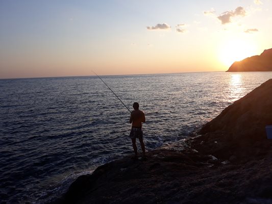 Български рибар замята за зарган по залез слънце на Тасос
