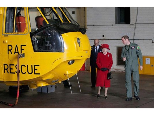 Принц Уилям показва на кралица Елизабет Втора и съпруга й принц Филип хеликоптера, с който лети от RAF Valley при спасителни операции. 
СНИМКА: РОЙТЕРС
