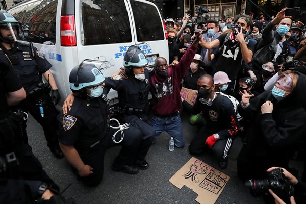 Полицаи коленичат пред демонстранти на протест в Манхатън.

