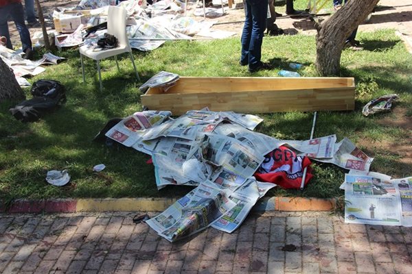 Тялото на жертва на атентата в Суруч лежи покрито с вестници, до него е поставен ковчег.