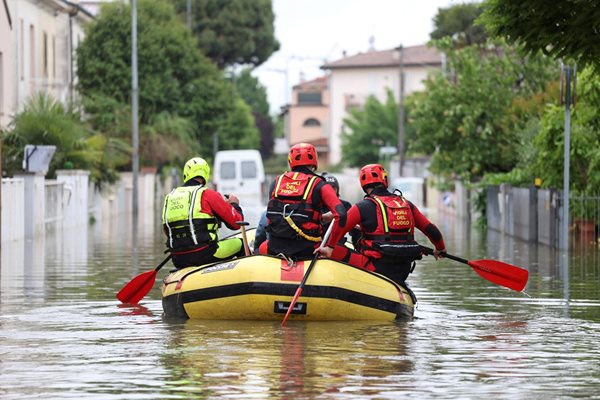 Пожарникари транспортират храна и вода до хората, които все още не могат да напуснат домовете си, след като проливните дъждове удариха италианския регион Емилия Романя. СНИМКА: РОЙТЕРС