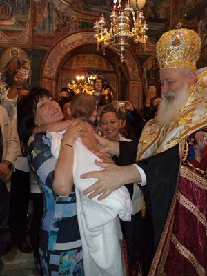 Дядо Сионий подава вече кръстеното момиченце на Цвета Караянчева.