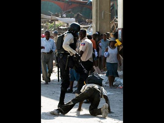 Хаитянски полицай рита мъж по време на акция срещу мародери в Порт-о-Пренс. 
СНИМКИ: РОЙТЕРС