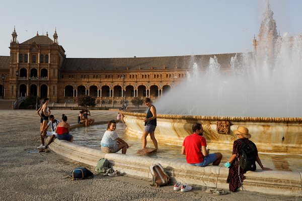 Туристи се разхлаждат във фонтан на фона на гореща вълна в Севиля, Южна Испания.