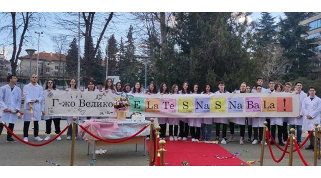 12-класници в Бургас опънаха червен килим за учителката си по химия пред входа на гимназията и облечени в бели престилки, я поканиха на бала си.
СНИМКА: БНР БУРГАС