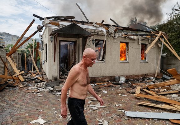 Местен жител ходи, докато къщата на съседа му гори след обстрел в Лисичанск, Украйна.
СНИМКА: РОЙТЕРС