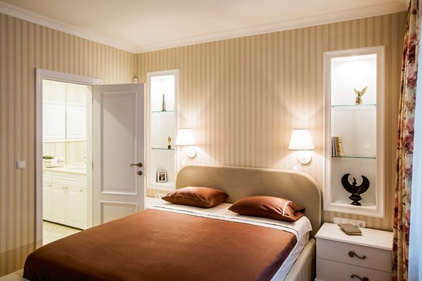 Родителската спалня е решена с две осветени ниши. Леглото е изработено в базата на DLINTERIOR с текстил на "Велекс"
