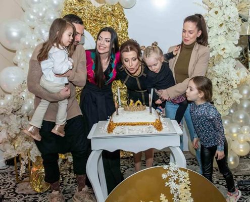 Съпругът на Виолета (вдясно) Георги Коруджиев е гушнал дъщеричката на Славея Амили и заедно с малките Илиана и Асияна (в ръцете на мама Вили) помагат на баба да духне свещите на тортата.