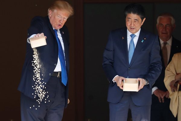 По време посещението си в Япония президентът на САЩ Доналд Тръмп беше фотографиран да изсипва цялото съдържание на кутия с храна в езерце с шарани кои.  СНИМКИ: РОЙТЕРС