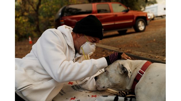 Жител на Калифорния се радва на оцелялото си куче.  СНИМКИ: РОЙТЕРС