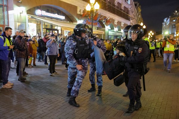 Полицаи задържат протестиращ в Москва.