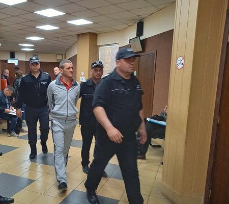Охраната води Николай Накев към съдебната зала. 