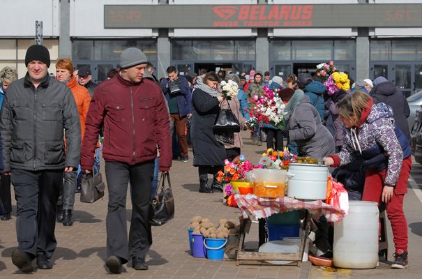 Жени продават зелечуци и изкуствени цветя в Минск, където мерките са нулеви и хората не носят маски.
