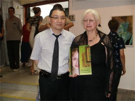 Явора Стоилова със супруга си Кен на откриването на изложба на Василия в Кюстендилската галерия. Тя показва албума към книгата, посветена на дъщеря й.