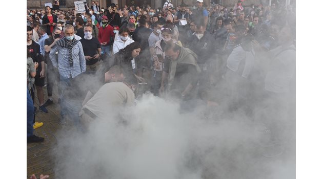 Протестиращи се опитват да изгасят огромна димка, метната на жълтите павета в понеделник вечерта. 