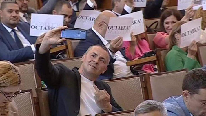 24 февруари: Христо Петров от ПП, по-известен като Ицо Хазарта, си прави селфи, на което показва среден пръст на фона на депутатите от ГЕРБ, вдигнали надписи “Оставка” към правителството.
