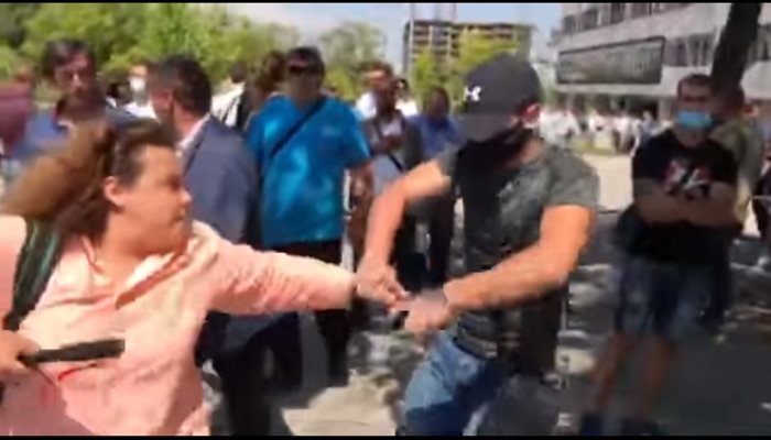 Стопкадър от видео, заснето от Генка Шикерова, на което се вижда как агресивен младеж взема телефона на журналистката Полина Паунова. 