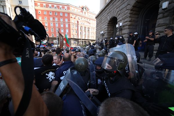 Протестиращите от “Възраждане” с черните тениски и хоругви бяха на първа линия пред полицейския кордон.