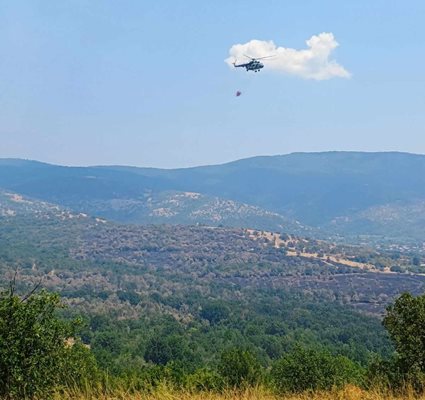 Хеликоптер облива с вода пламъците в района на Отец Паисиево.