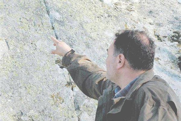 Археологът Борислав Бориславов показва знак, изсечен в скалата.
СНИМКИ: АТАНАС КЪНЕВ