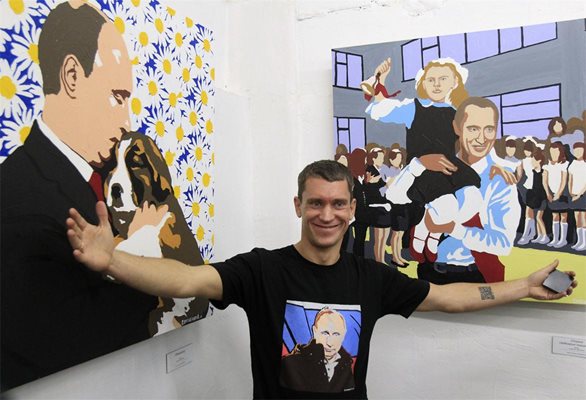Художникът Алексей Сергиенко представя изложбата си за Путин. Вляво е картина, наподобяваща снимката, на която президентът целува кученце, подарено му у нас.