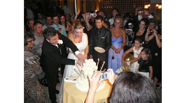 СЕМЕЙСТВО: Константин и Надя разрязват сватбена торта пред погледа  на приятели и родини. 
