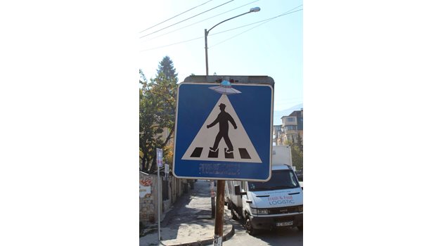 Първият пътен знак, който претворява уличният артист, е на пешеходец с НЛО.