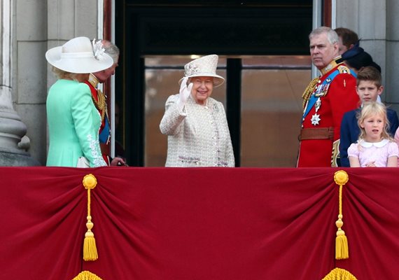 Кралица Елизабет помаха с ръка и се усмихна, когато се появи на балкона, а тълпата я аплодира.