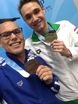 Антъни Иванов и победителят на 200 м бътерфлай от Унгария Крищоф Милак показват медалите си.  Снимка: фейсбук на Антъни Иванов