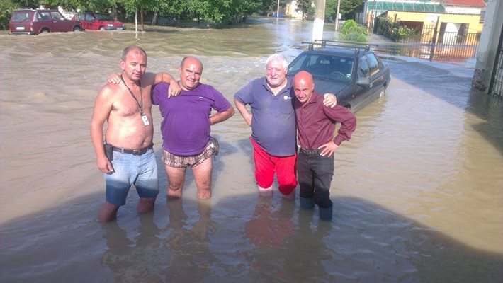 Журналистът се снима с мъже в Мизия през август 2014 г., когато отразява наводнението в града.