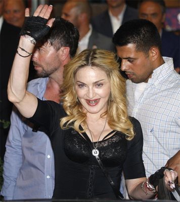 Мадона сащиса фенове и журналисти при излизане от фитнес салон в Рим тази седмица. Тя откри европейски клон на веригата си зали “Хард кенди” в италианската столица.